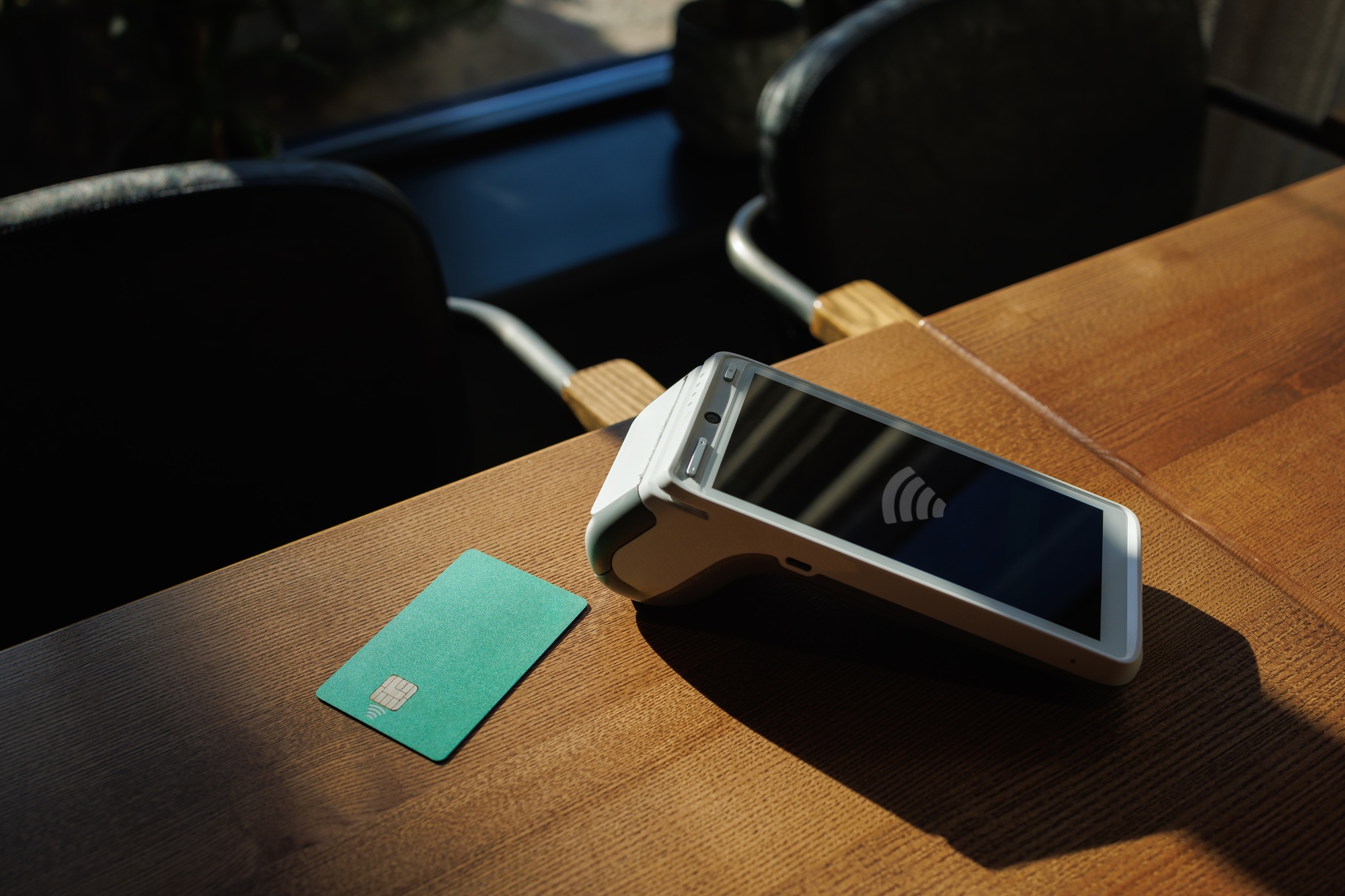 Close-up of payment terminal and credit card on table background. Credit card payment.